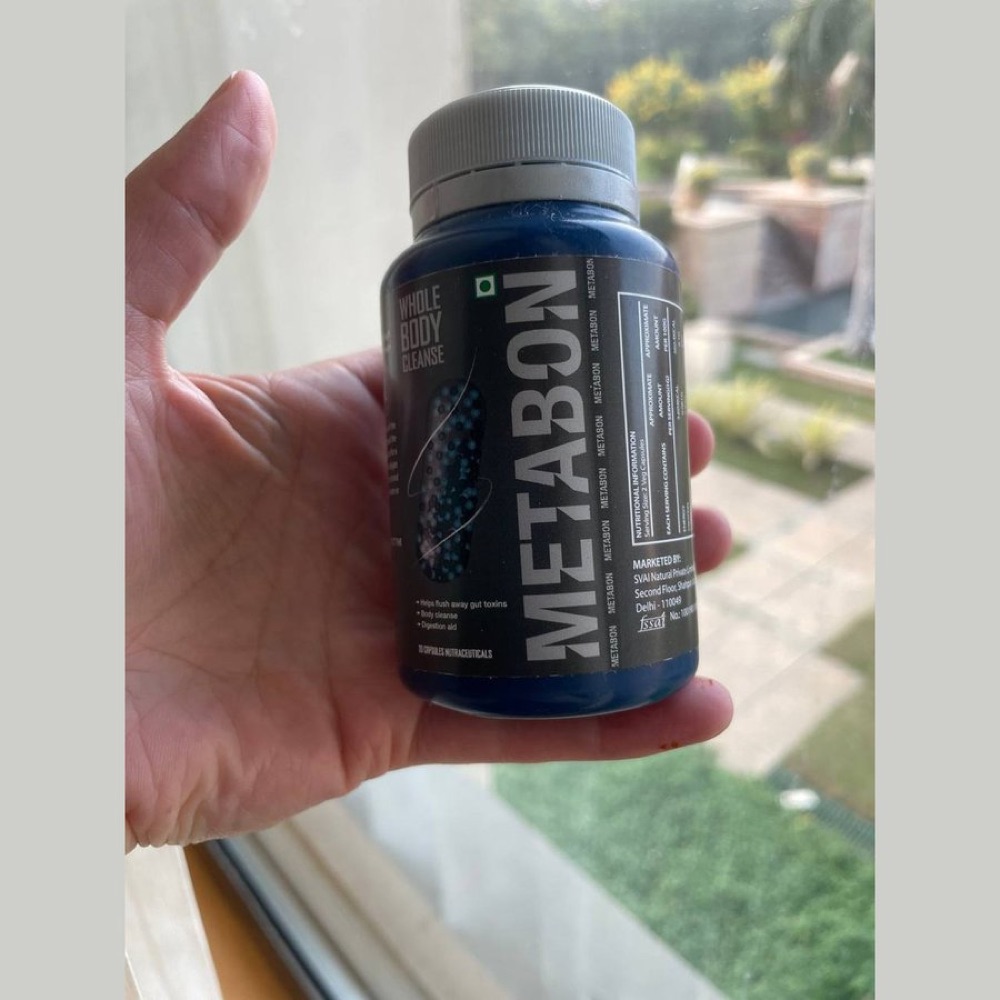 Dark blue Metabon bottle held in hand